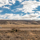 Desert, sky, the back of a billboard along a road, and Mike getting out of his car